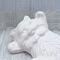Close up of unpainted ceramic kitty showing its face and front paws.